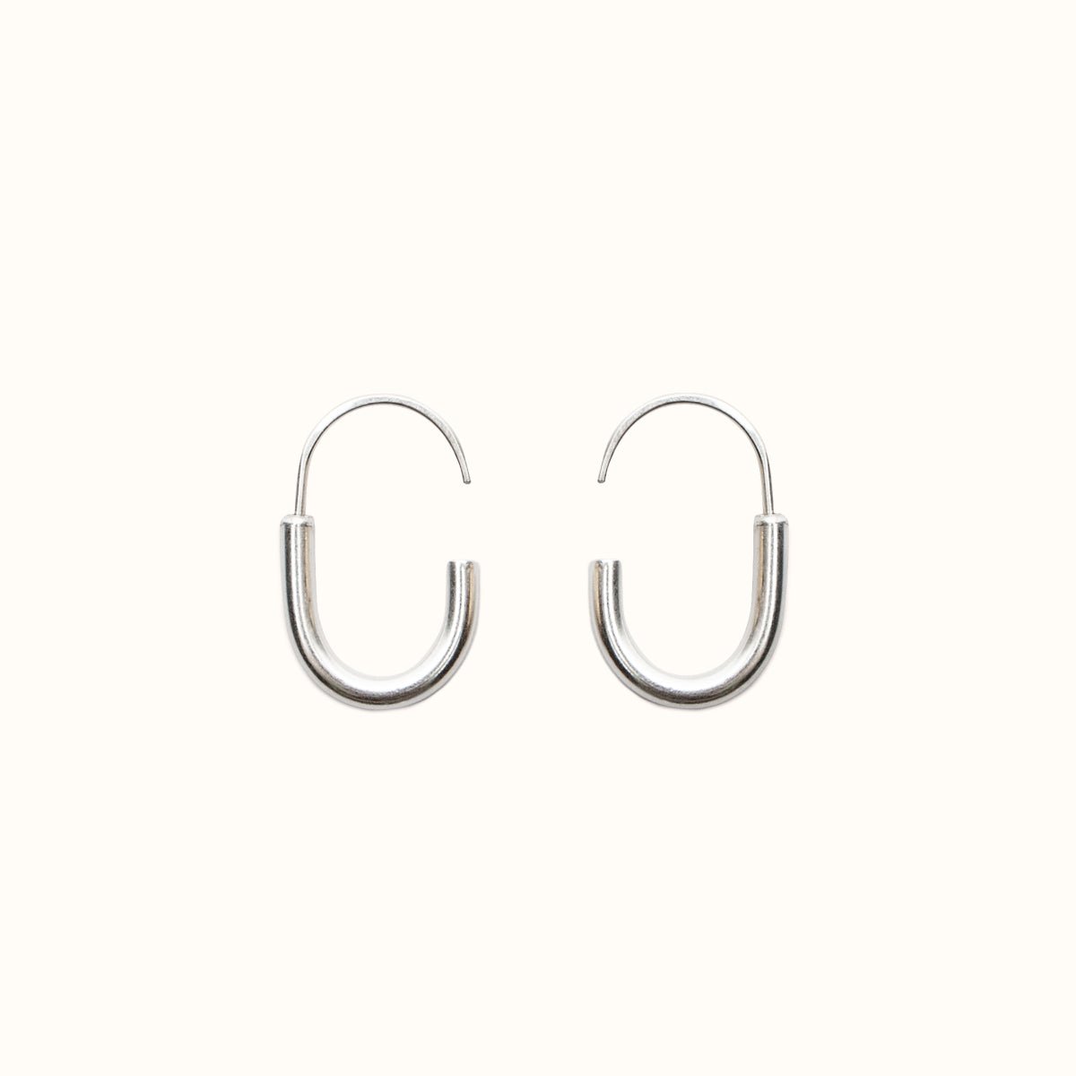 A mini brass hoop U-shaped earring with an arched sterling silver ear wire with a slight opening. Designed and handcrafted in Portland, Oregon.