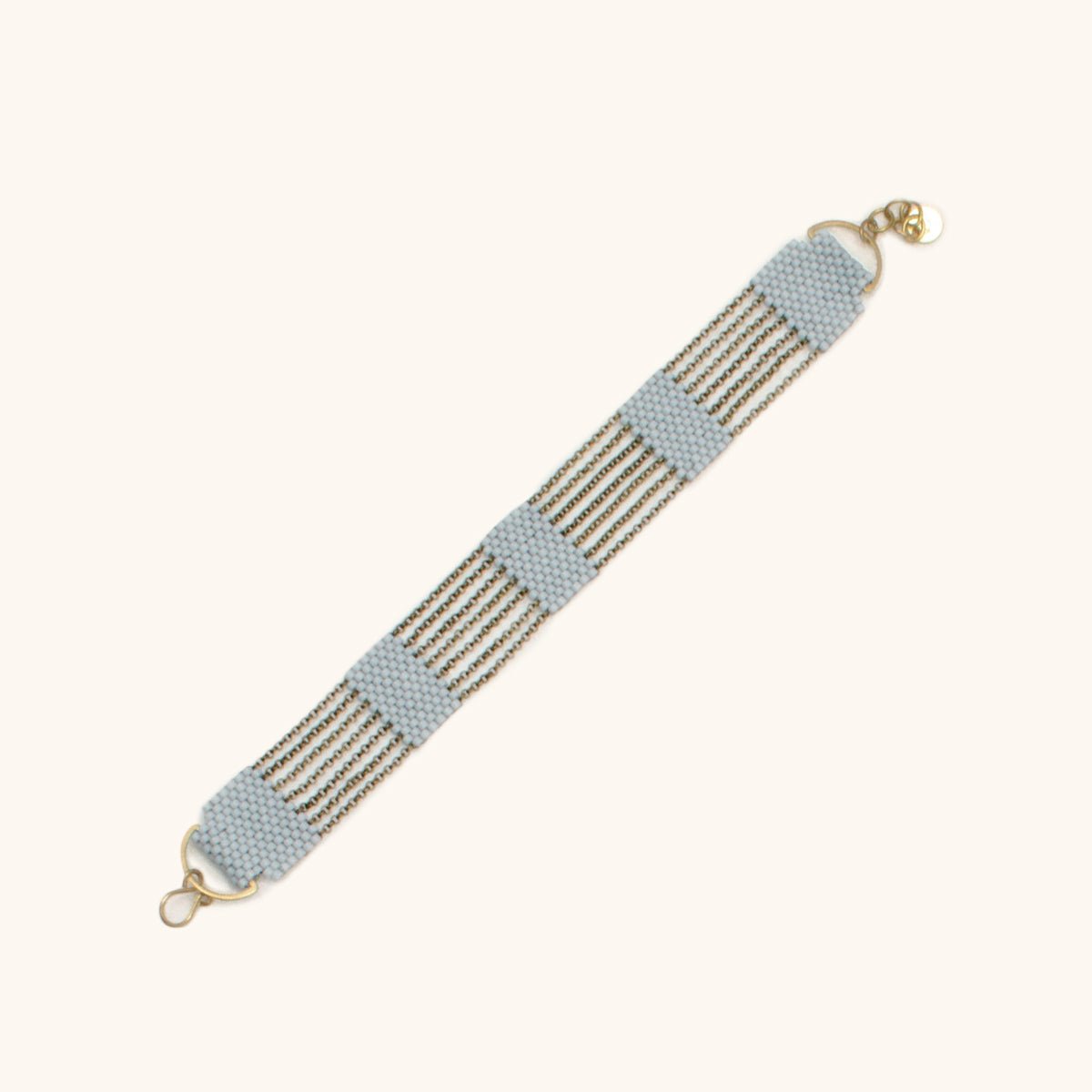 A 5 tier beaded bracelet made with blue grey beads and antique brass chains. Handmade by A Nod To Design in Portland. OR.