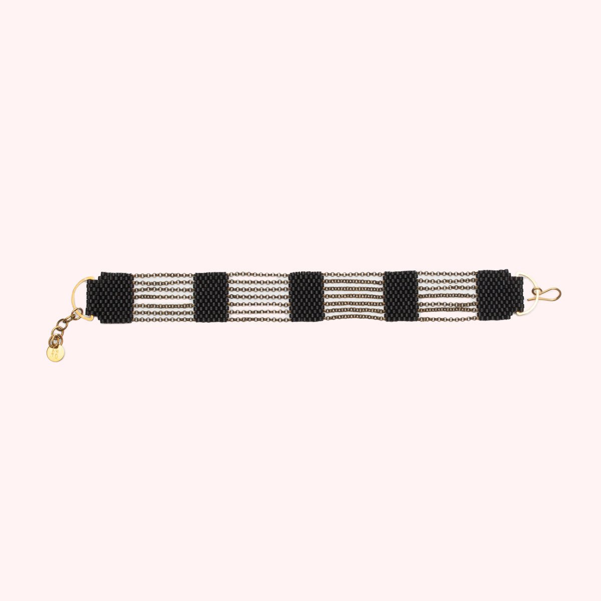 A 5 tier beaded bracelet made with black beads and antique brass chains. Handmade by A Nod To Design in Portland. OR.