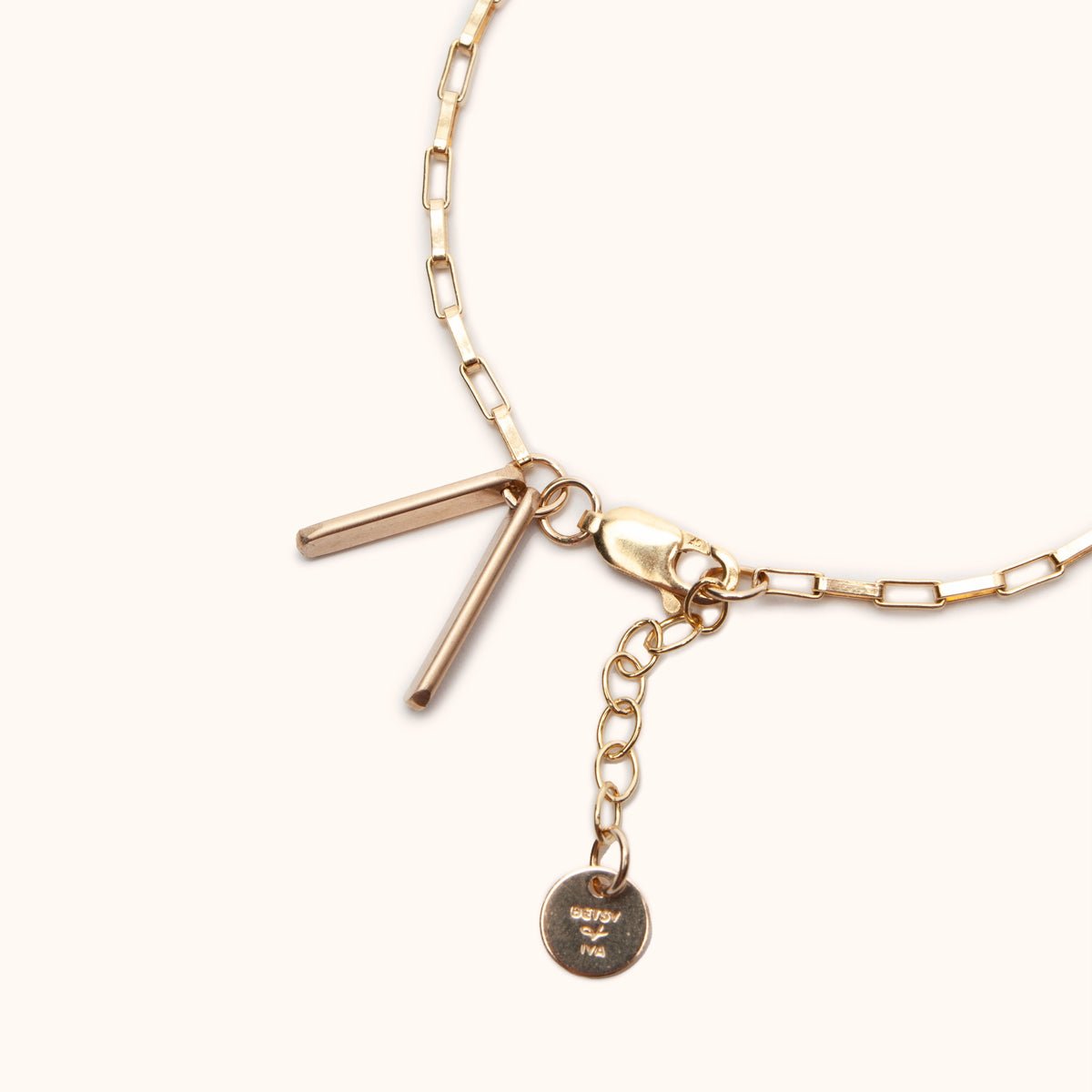 A close up look of the lobster clasp and two rectangular gold fill tags on a delicate gold fill chain. The Alba Bracelet can be adjusted using the attached jump rings. Designed and handcrafted in Portland, Oregon.