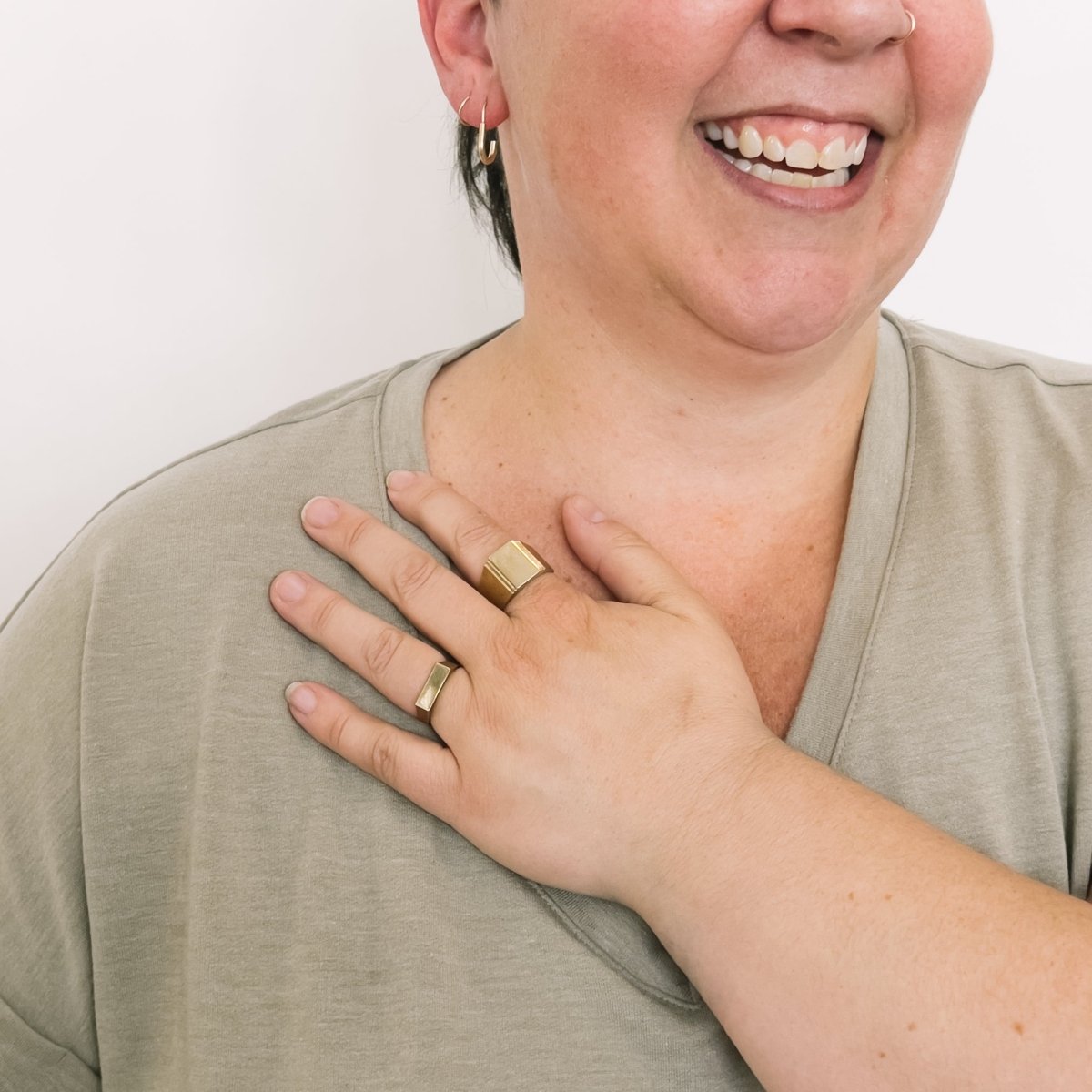 Model wears a narrow signet ring on the ring finger and a wide band signet style ring on the pointer finger. Both rings are made in bronze. Designed and handcrafted in Portland, Oregon.