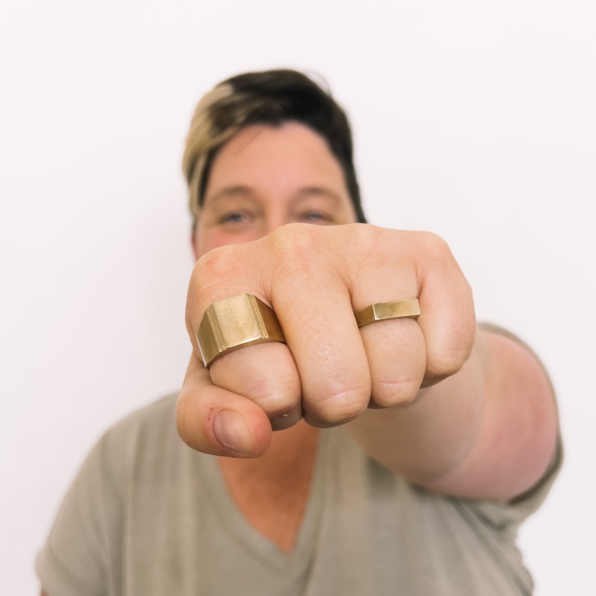 Model wears a narrow signet ring on the ring finger and a wide band signet style ring on the pointer finger. Both rings are made in bronze. Designed and handcrafted in Portland, Oregon.