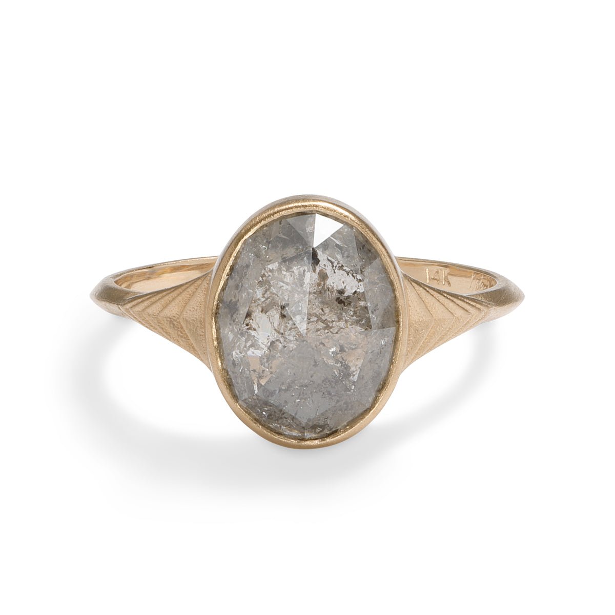 Modern oval Nubis ring with a salt & pepper diamond. 14K gold band features geometric engravings.