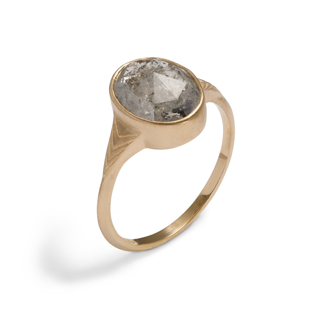 Modern oval Nubis ring with a salt & pepper diamond. 14K gold band features geometric engravings.
