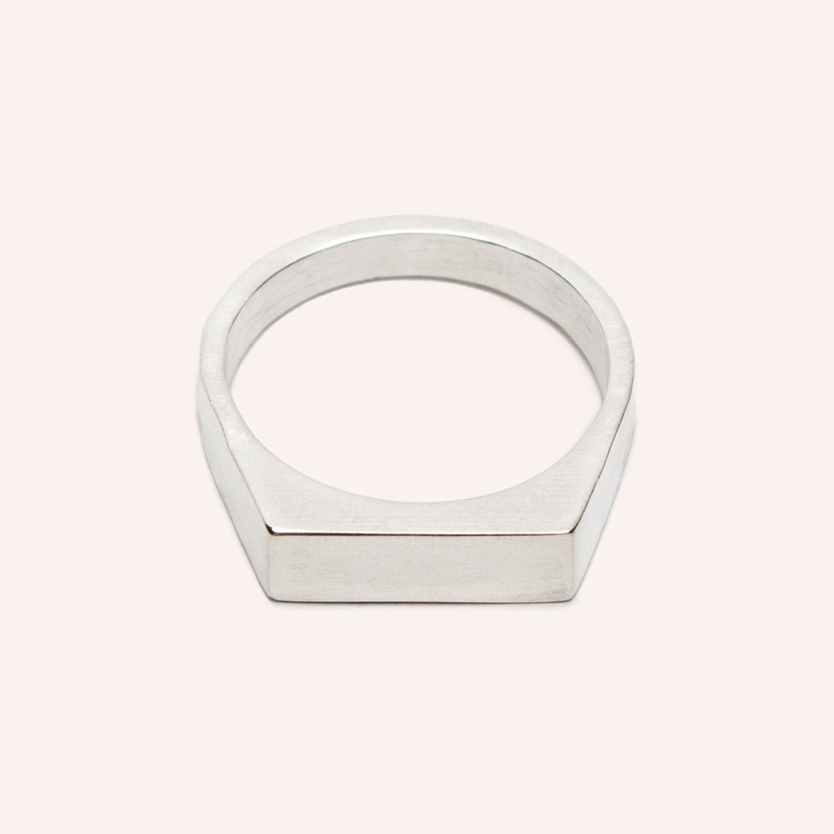 A narrow signet ring with a polished rectangular top and hammered detail on the band. Made in solid sterling silver. Designed and handcrafted in Portland, Oregon.