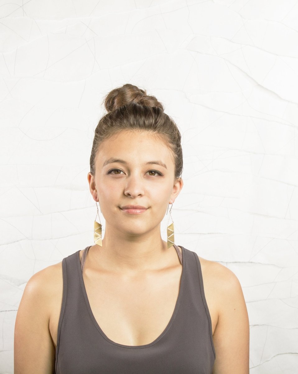 Mixed metal triangle dangle betsy & iya earrings are displayed on a model.