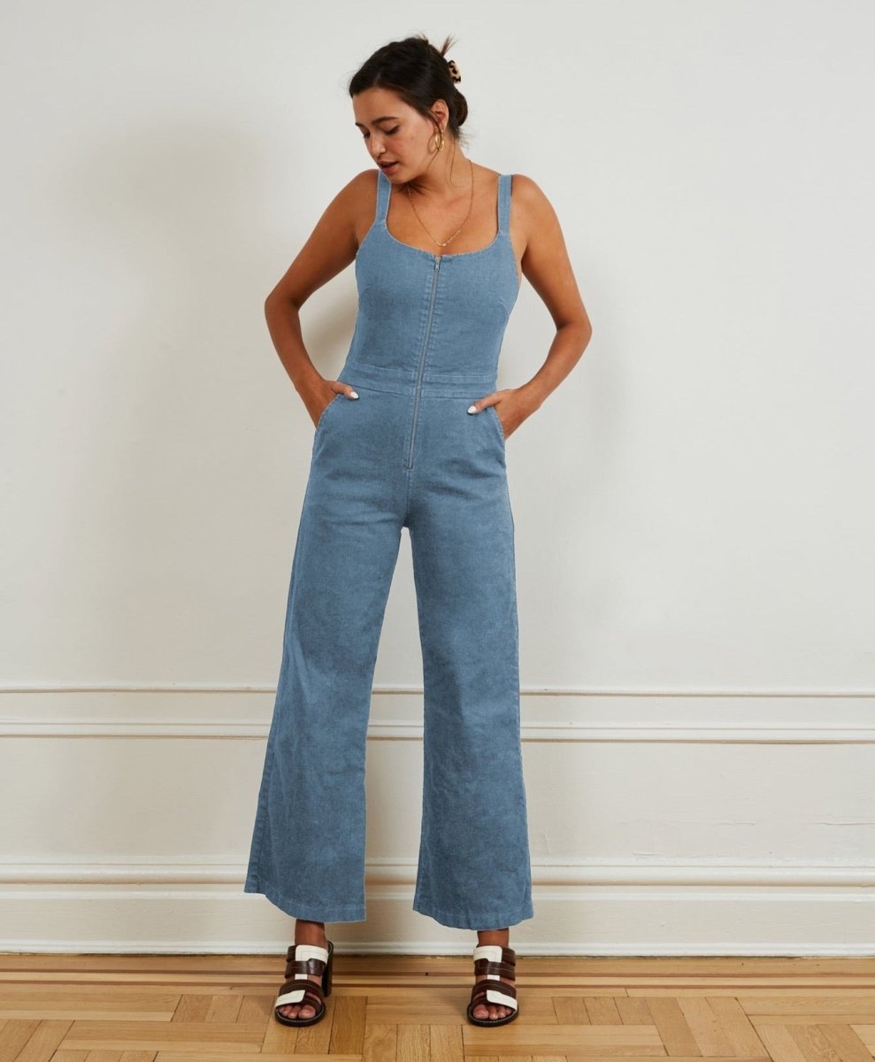 A light blue denim jumpsuit with narrow straps, flared bottom and zipper up the front. The Billy Jumpsuit in Light Indigo is designed by Loup and made in New York City, USA.