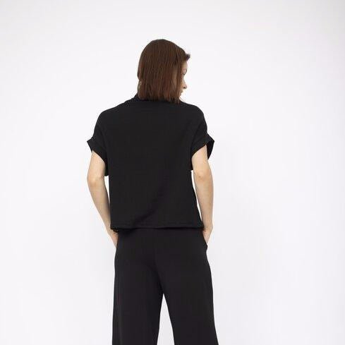 A draped short sleeve top with a slouchy mock neck in Black. Fabric and top made in Los Angeles, CA by Corinne Collection.