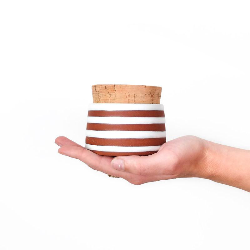 Model holding Wolf Ceramics Corked Jar White Horizontal Stripes