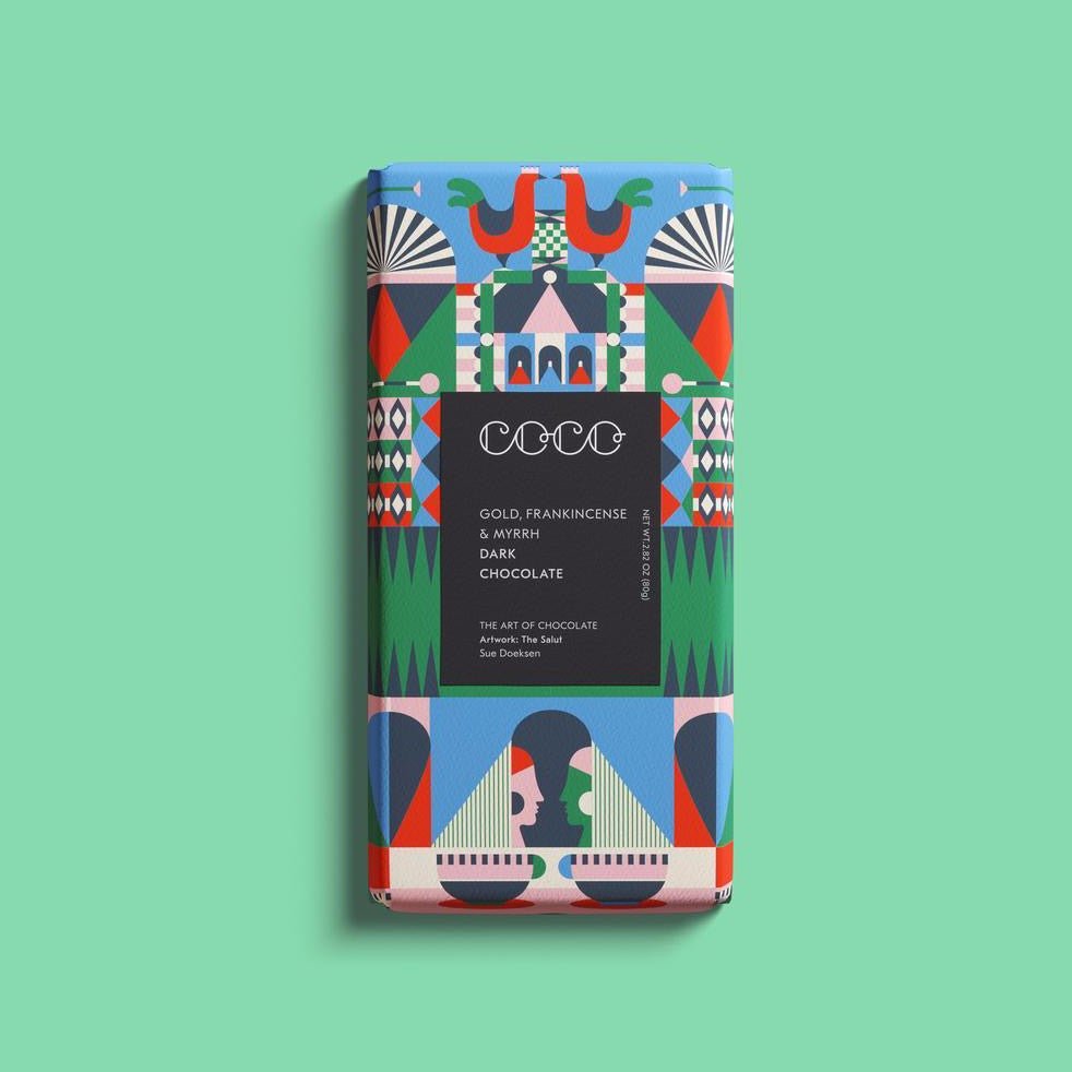 Gold, Frankincense & Myrrh Chocolate Bar wrapped in a blue, green, pink and white wrapper. Artwork is designed by artist Sue Doeksen. COCO Chocolatier is based in Edinburgh, Scotland.