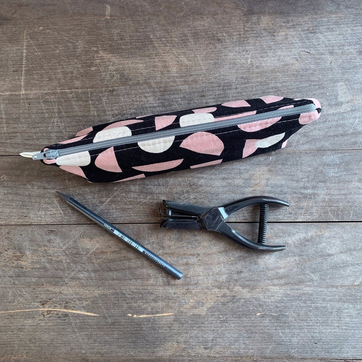 Narrow black canvas pencil case with pink and cream colored concentric shapes. Designed and handmade by Frankie & Coco in Portland, Oregon.
