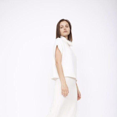 A draped short sleeve top with a slouchy mock neck in Ivory. Fabric and top made in Los Angeles, CA by Corinne Collection.