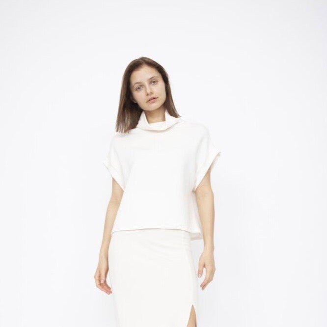 A draped short sleeve top with a slouchy mock neck in Ivory. Fabric and top made in Los Angeles, CA by Corinne Collection.