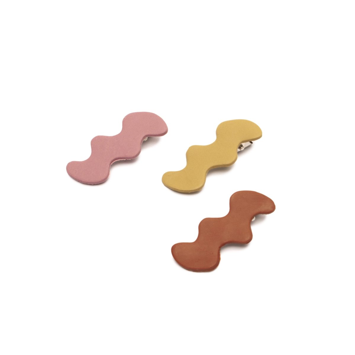 Three Squiggle Hair Clips in the shade Lilac, Thistle and Sienna. Made by Hey moon Designs in Los Angeles, CA.