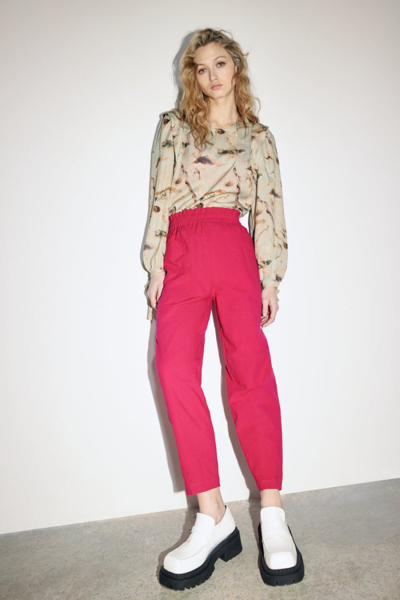 A straight leg pant in a bright pink color with an elastic waistband. The Izmir Pants in Fuchsia is designed by Eve Gravel and made in Montreal, Canada.