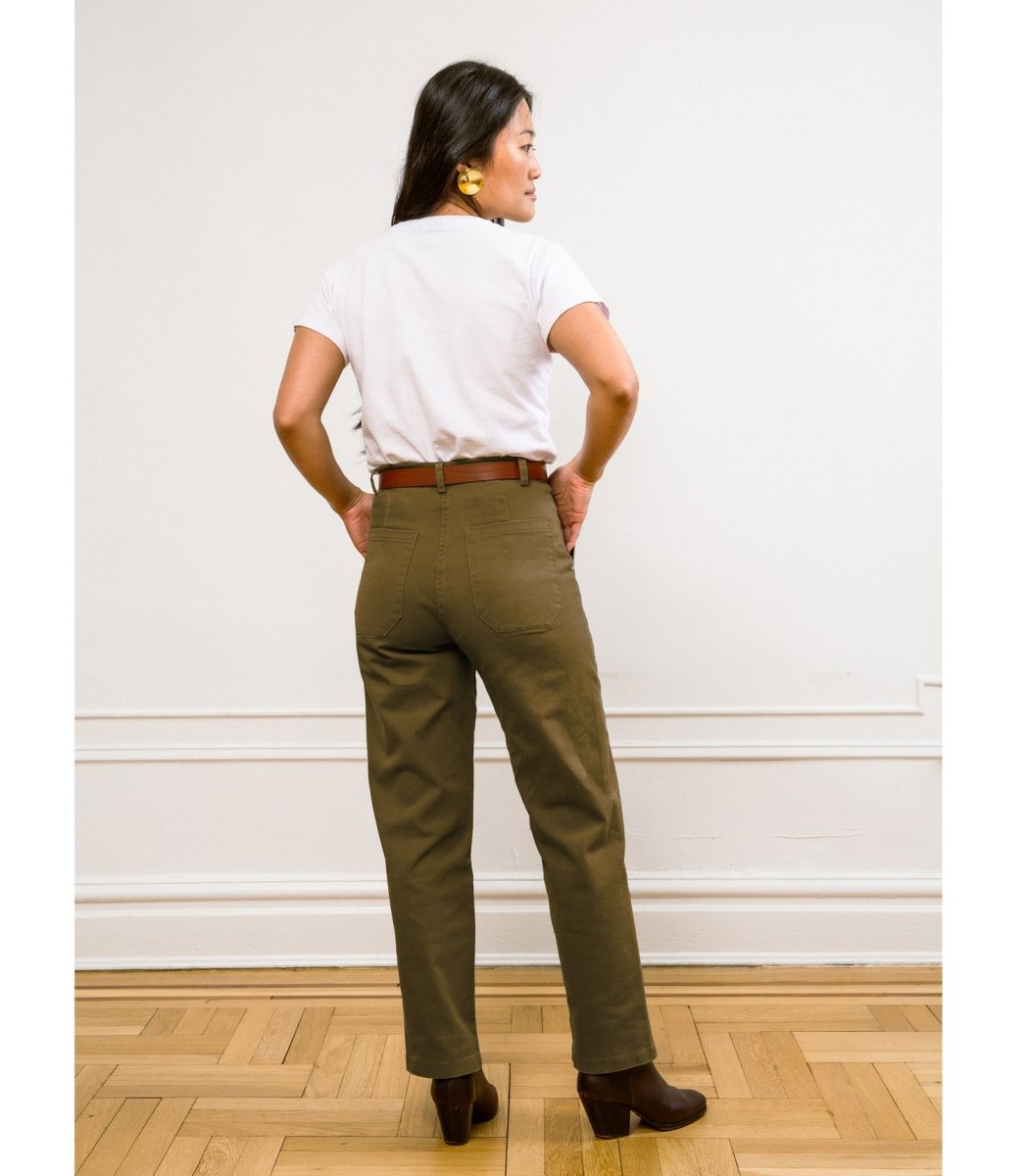 Model wears a straight leg cropped work pant in an army green. The James Pant in Moss Green is designed by Loup and made in New York City, USA.