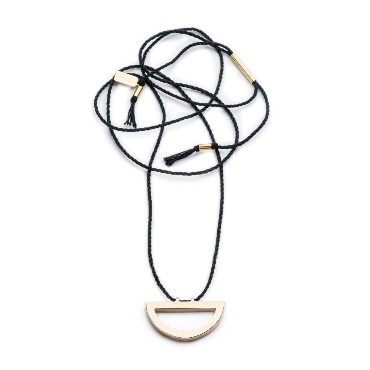 Modern, adjustable necklace of black Japanese cotton rope threaded along the long end of a cast bronze semi-circle pendant with brass tubing accents and black cotton fringe. Hand-crafted in Portland, Oregon.