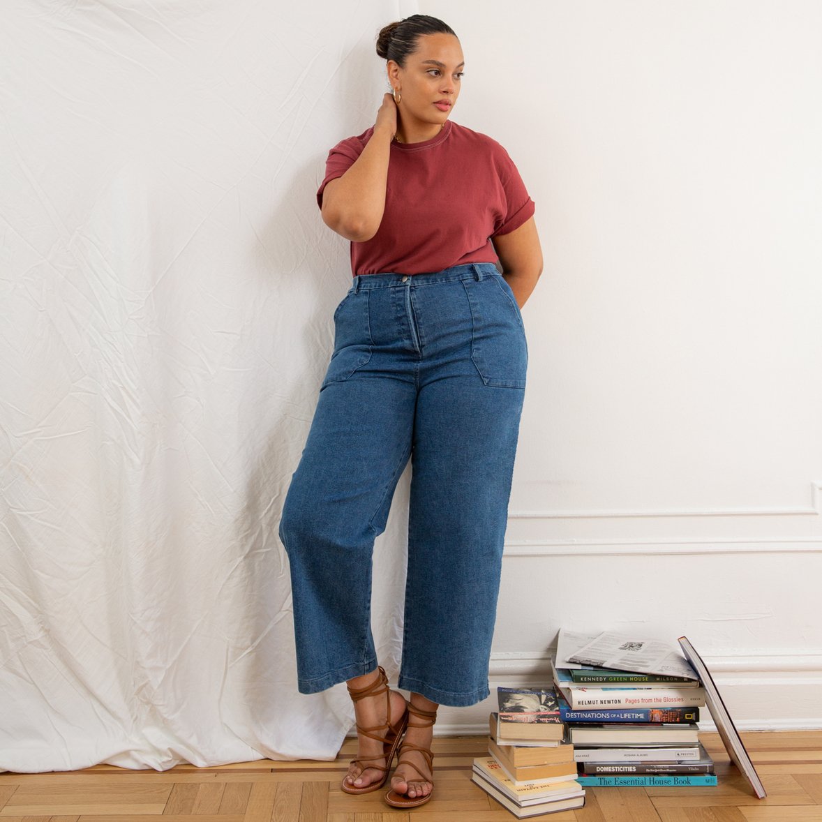 A model wears a high waisted wide leg crop jean in a blue denim. The Kate jean in Medium Indigo are designed by Loup and made in New York City, USA.