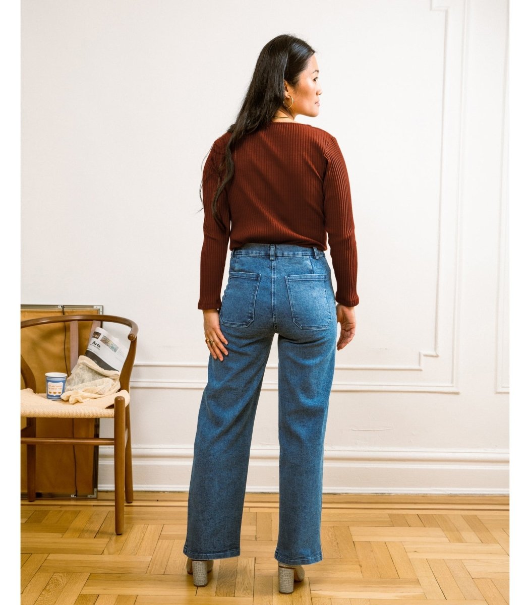 A model wears a high waisted wide leg crop jean in a blue denim. The Kate jean in Medium Indigo are designed by Loup and made in New York City, USA.