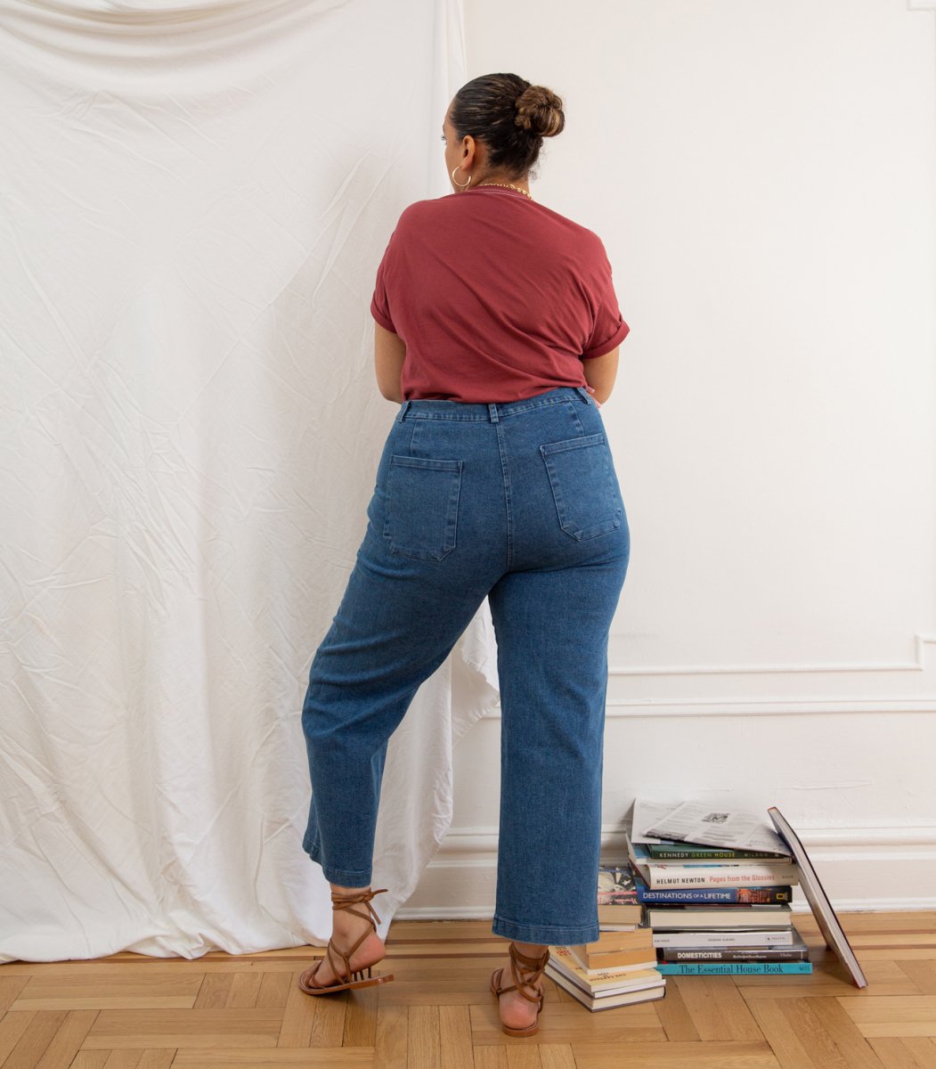 A model wears a high waisted wide leg crop jean in a blue denim. The Kate jean in Medium Indigo are designed by Loup and made in New York City, USA.