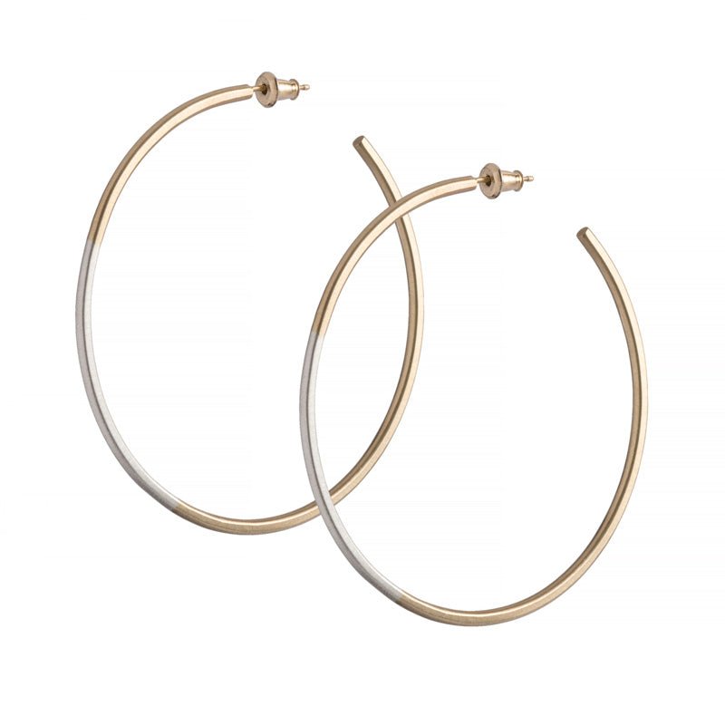 Minimalist, lightweight, mixed metal hoops of 14k yellow gold and sterling silver hand-forged wire, with 14k gold earring posts and ear nuts. Size large, two and one-eighth inches in diameter. Hand-crafted in Portland, Oregon.