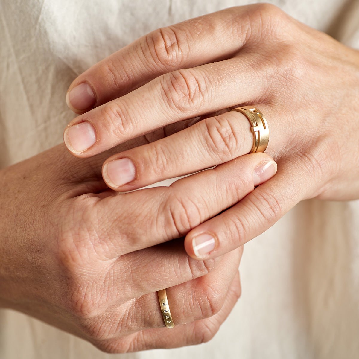 Model wears the Linea and Sero rings on their left hand. The Aurum ring is featured on their right hand.