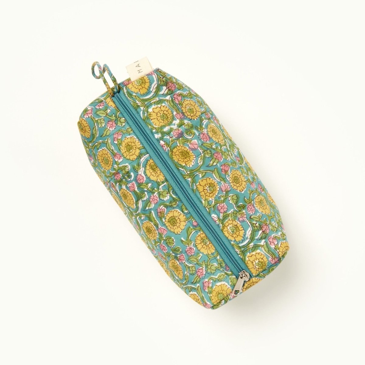 A green, blue, yellow and pink floral patterned makeup bag. The Fiona Makeup Bag from Maelu is designed in Portland, Oregon and printed in India.