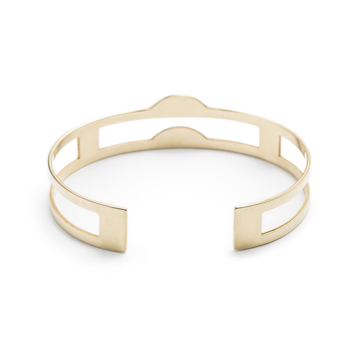 Edgy, lightweight, and adjustable cuff bracelet of polished brass, with three rectangular cutouts through the center of the cuff and two semicircle-shaped peaks at the front of the cuff. Hand-crafted in Portland, Oregon.
