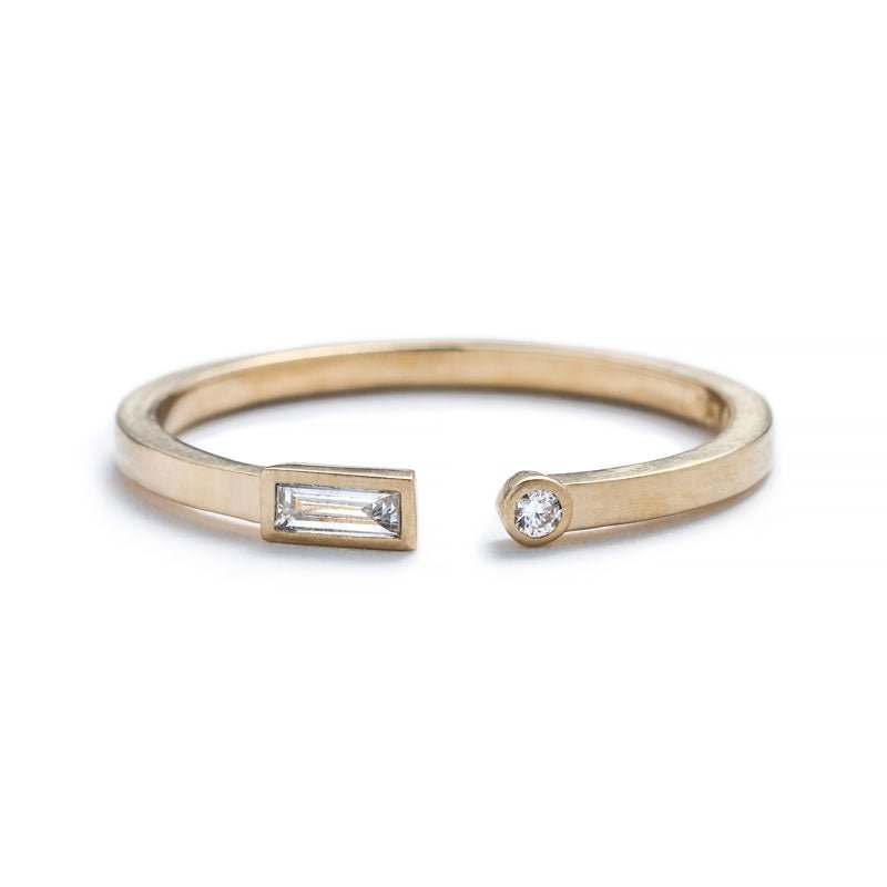 Thin, 14k yellow gold adjustable ring with a matte finish, bezel-set with a small, white diamond baguette on one end, and a small, white, round diamond on the opposite end. Hand-crafted in Portland, Oregon.