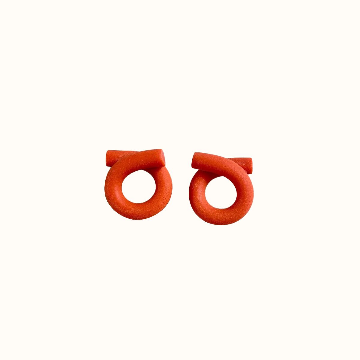 Polymer clay stud earrings in a loop formation and bright poppy color. The Medium Loop Earrings in Poppy are designed and handcrafted by Little Pieces Jewelry in Los Angeles, California.