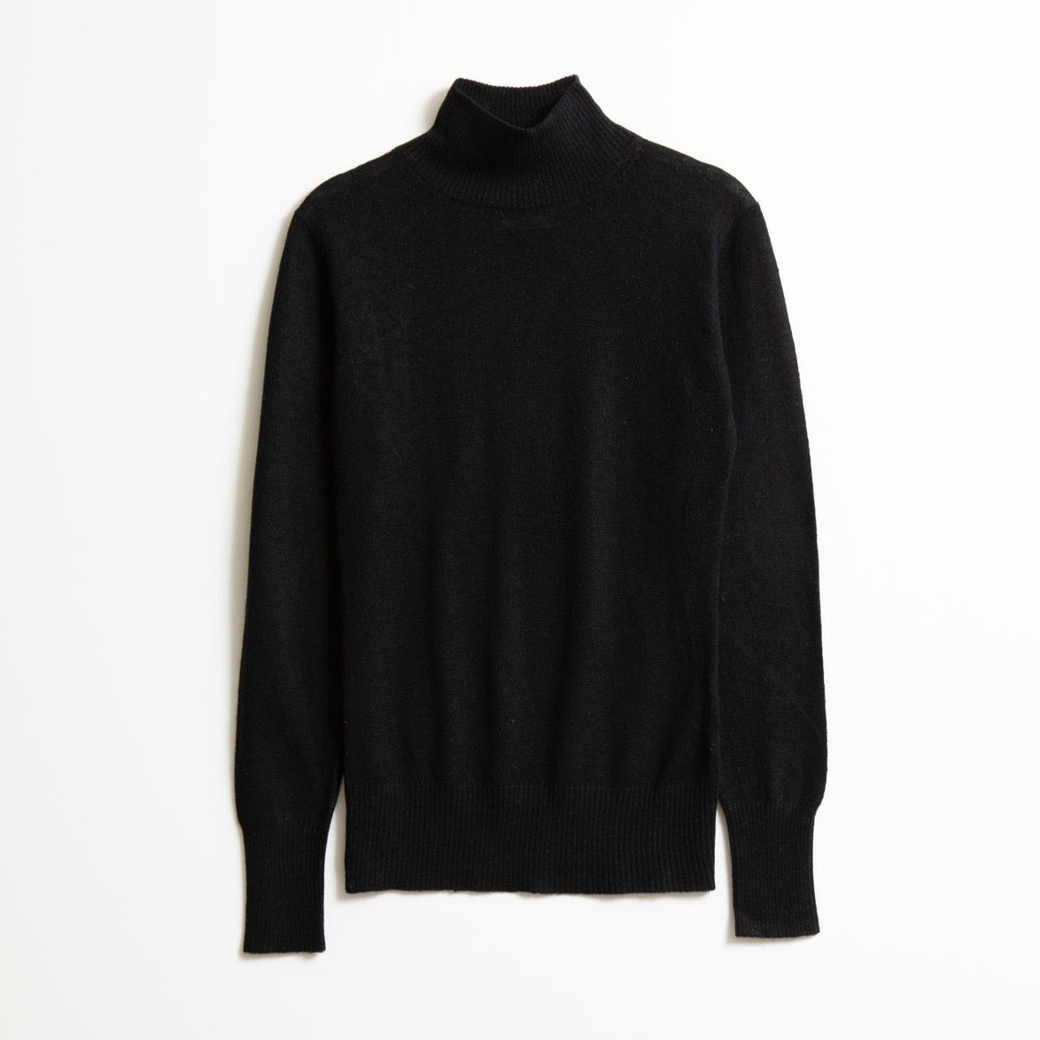 A long sleeve knitted mock neck turtleneck in black. The Merino Turtleneck in Black is designed by Dinadi and hand knitted in Kathmandu, Nepal.
