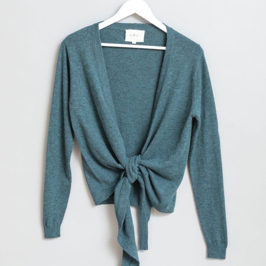 Blue/Green knitted wrap cardigan displayed on a white hanger. The Merino Wrap Cardigan in Dragonfly Green in designed by Dinadi and made in Kathmandu, Nepal.