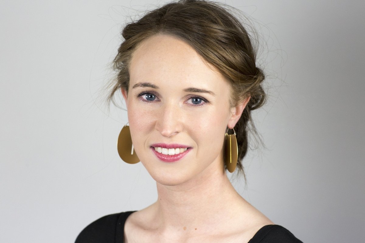Eye-catching, large betsy & iya Lié hoop earrings, styled on a model with an updo and a black top.
