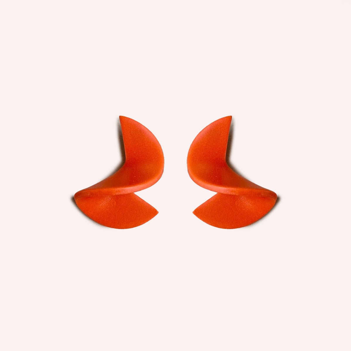 A polymer clay stud earring folded into a small wave. The Modern Crinkle Earrings in Poppy are designed and handcrafted by Little Pieces Jewelry in Los Angeles, California.