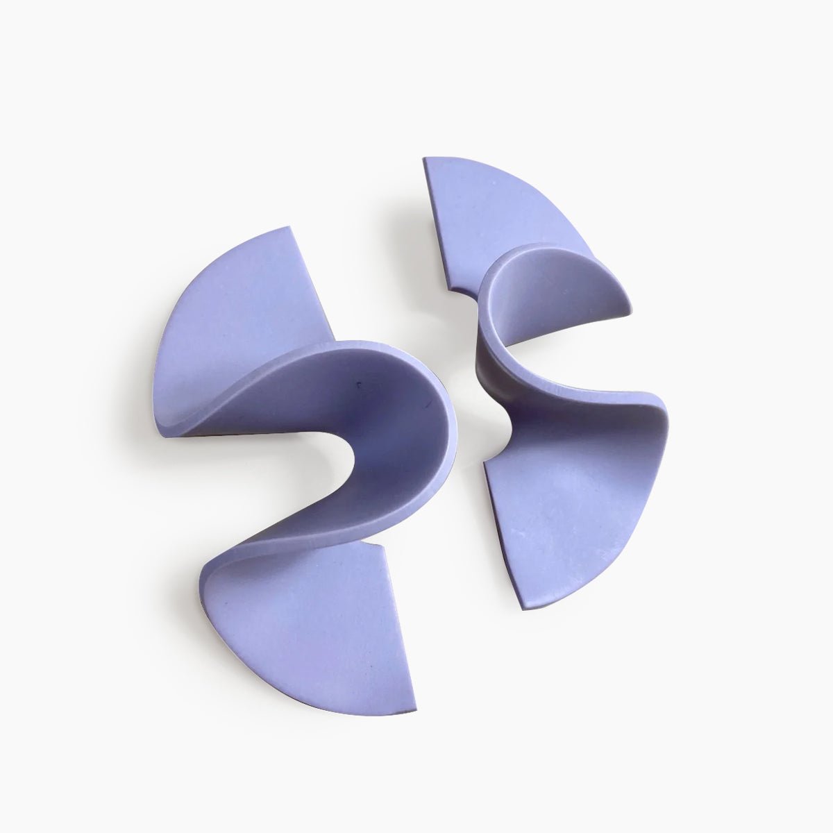 A wide band polymer clay stud earring in a wave design. The Modern Wave Earrings in Lilac are designed and handcrafted by Little Pieces Jewelry in Los Angeles, California.