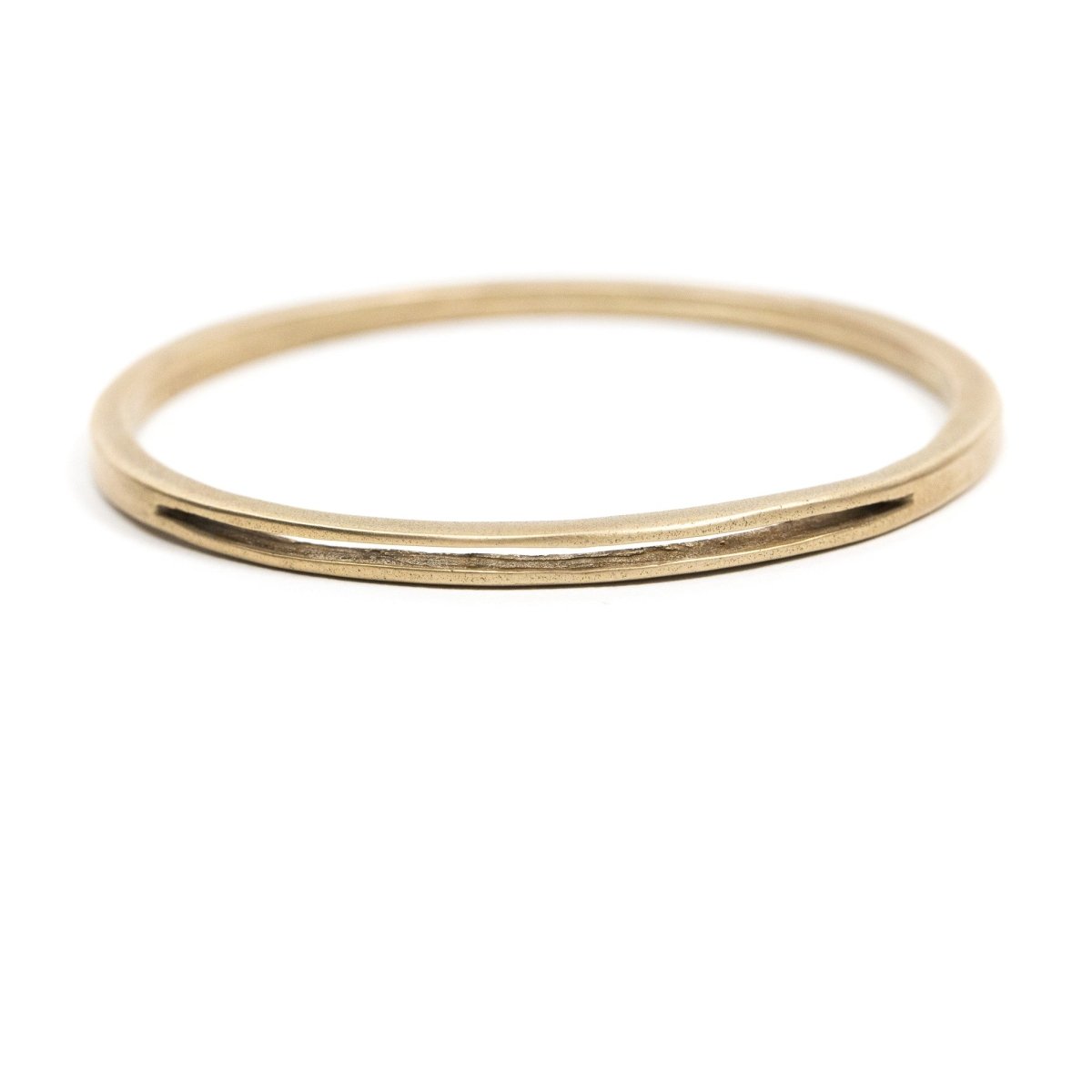 Sturdy, circular, cast-bronze bangle bracelet, featuring one long, slim, cutout slit in the metal. Hand-crafted in Portland, Oregon.