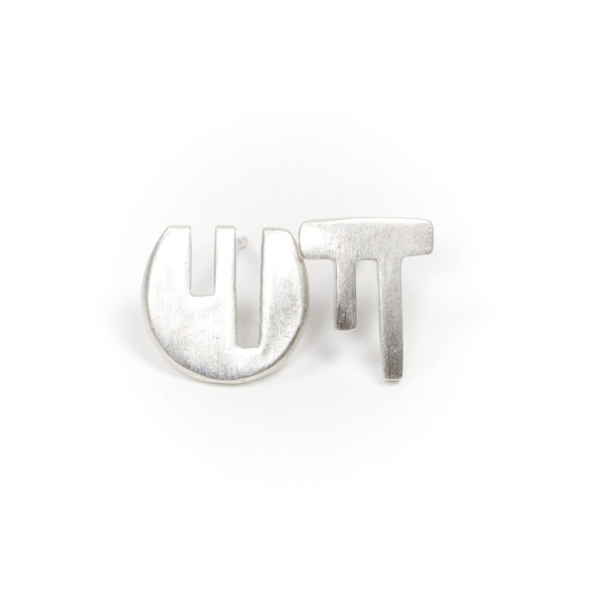 A pair of mismatched, fine silver stud earrings, with complementary geometric cutouts that fit into one another like puzzle pieces. Hand-crafted in Portland, Oregon.