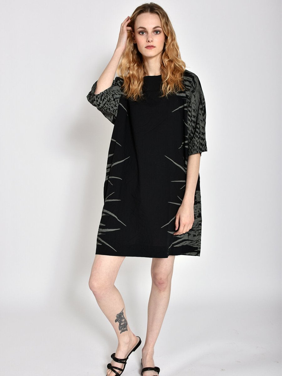 Short black dress with three-quarter sleeves and light grey feather pattern on sides. Designed and sewn by UZI in Brooklyn, New York.