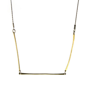 Three skinny golden brass bars form a geometric shape at the bottom of a long thin gunmetal chain.