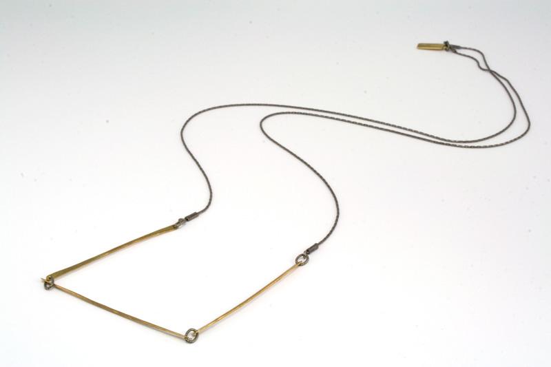 betsy & iya's Salt Plain necklace lays on a white table.