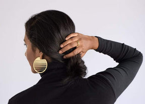 Ocaso circle statement hoops in brass on model