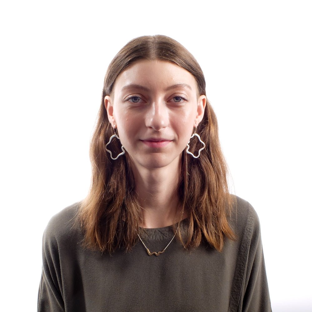 The bronze Semita necklace, styled on a model with complementary betsy & iya sterling silver Semita dangle earrings and an olive top by Tienda Ho.