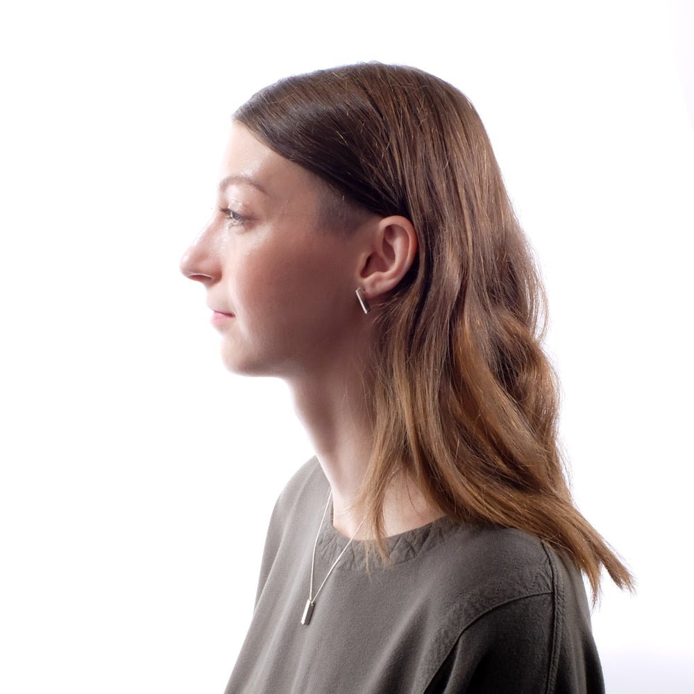 Bronze Dati stud earrings, styled on a model with a matching sterling silver betsy & iya Dati necklace and an olive green top by Tienda Ho.