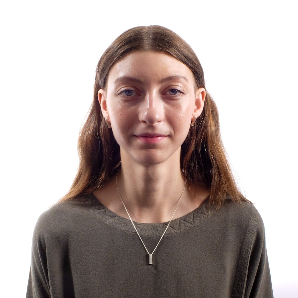 Sterling silver betsy & iya Dati necklace, styled on a model with matching bronze betsy & iya Dati stud earrings and an olive top by Tienda Ho.