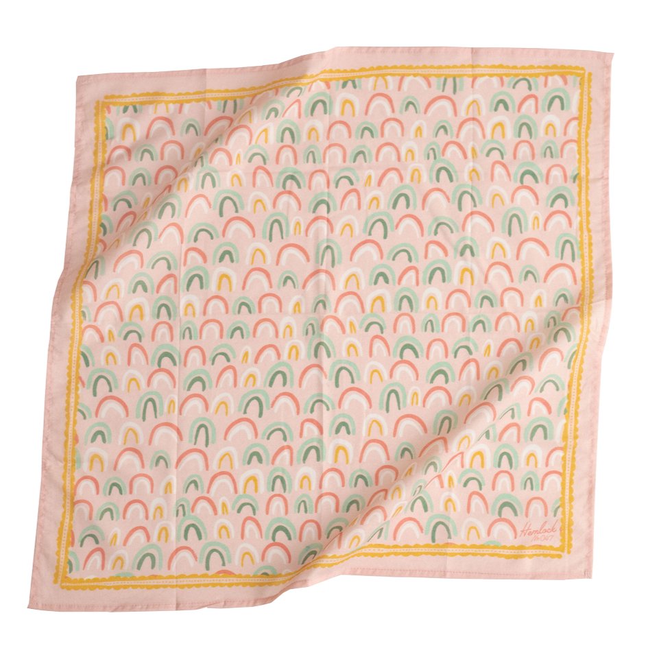 Light pink bandana with pastel  pink, green, yellow and white rainbow pattern. Designed by Hemlock Goods in Fulton, MO and screen printed by hand in India.