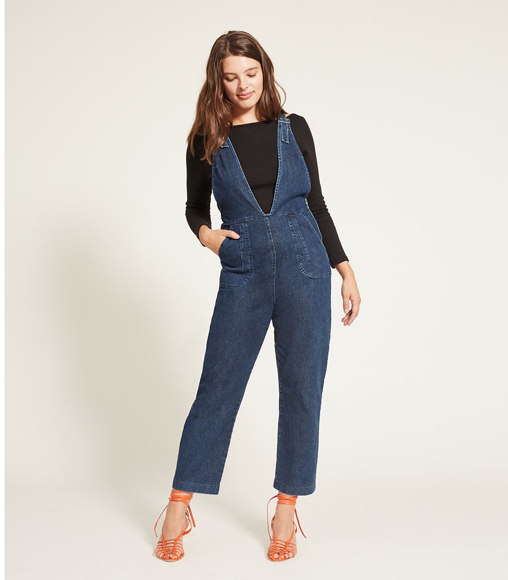 Model wears the Rhoda Coveralls in Indigo over a black long sleeved shirt. The Rhoda Coveralls in Indigo are designed by Loup and made in New York City, USA.