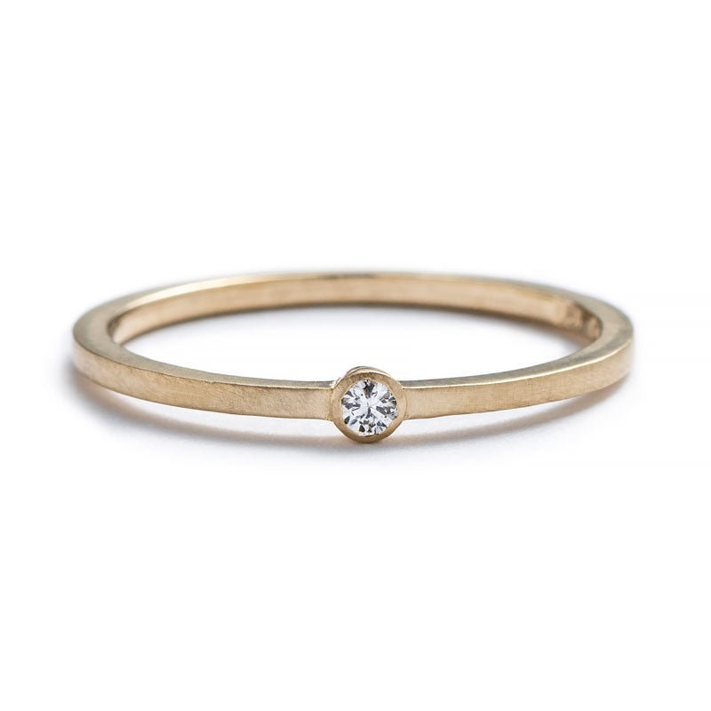 Thin, 14k yellow gold band with a matte finish, featuring a small, round, bezel-set white diamond. Hand-crafted in Portland, Oregon.