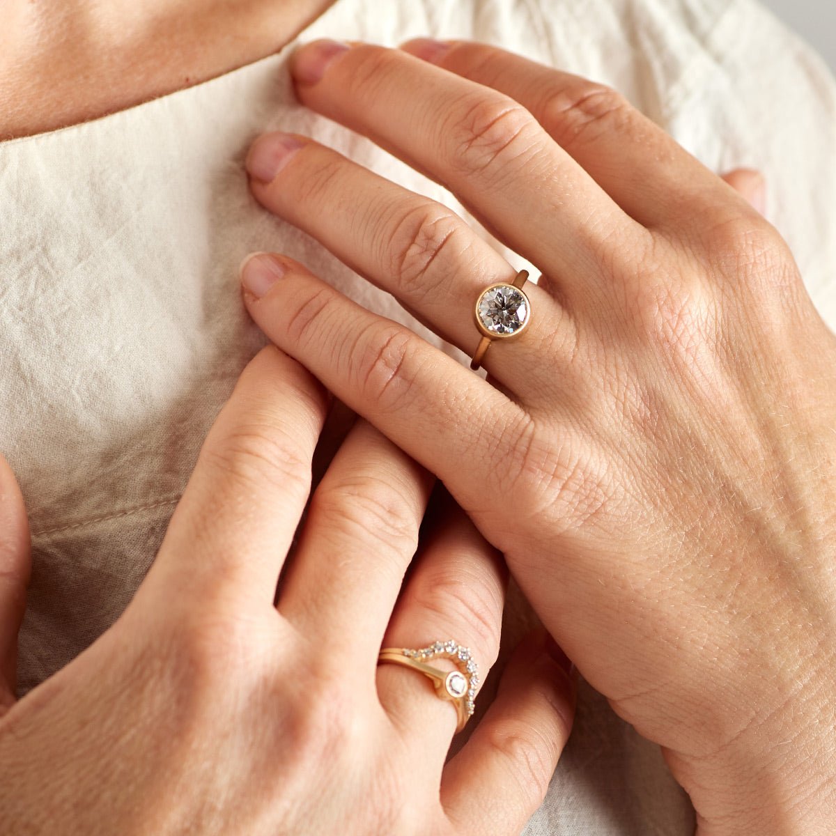 Model wears the Salire ring on their left hand, and the Ortus and Sano (0.25 ct) rings on their right hand.
