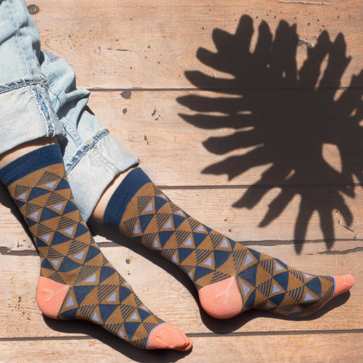 Light brown sock with navy blue triangular pattern and navy blue ribbed collar. Heel and toe are a light pink as well as the logo along the arch. The Sierra Sock in Bronze is from Zkano and made in Alabama, USA.