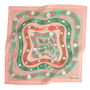 A pink bandana with a green, white and red floral snake pattern. Designed by Hemlock Goods in Fulton, MO and screen printed by hand in India.